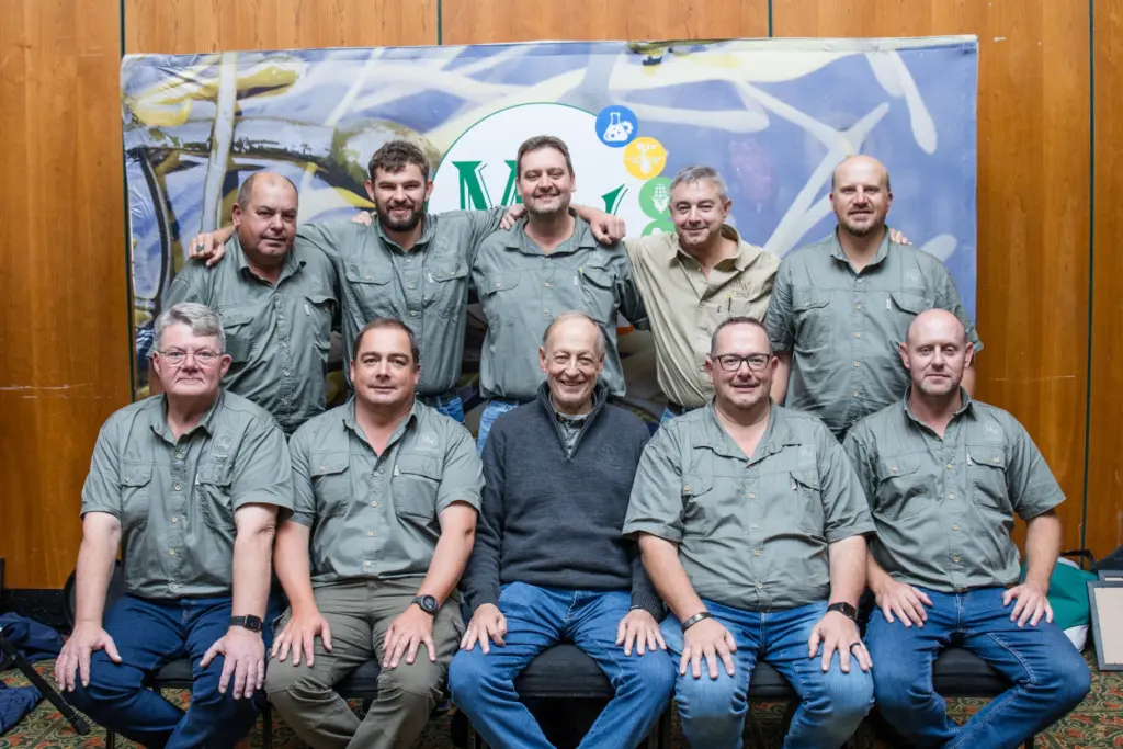 MetsonWorld technical sales team of nine in front of a branded backdrop